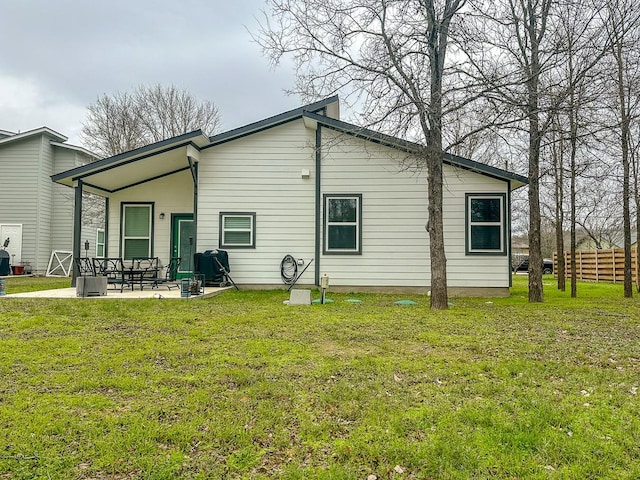 back of house featuring a lawn and a patio area