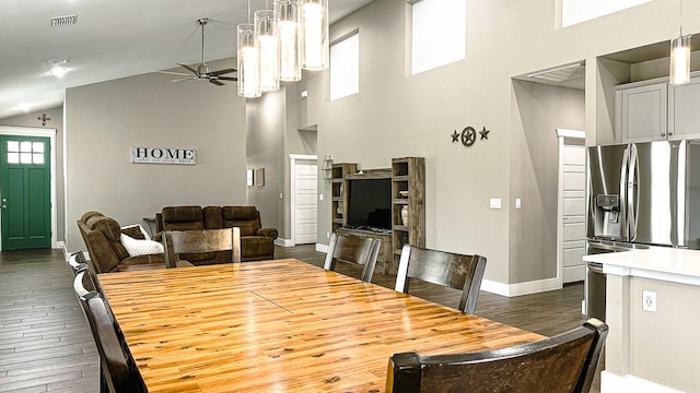 dining room with a high ceiling, ceiling fan, and dark wood-type flooring