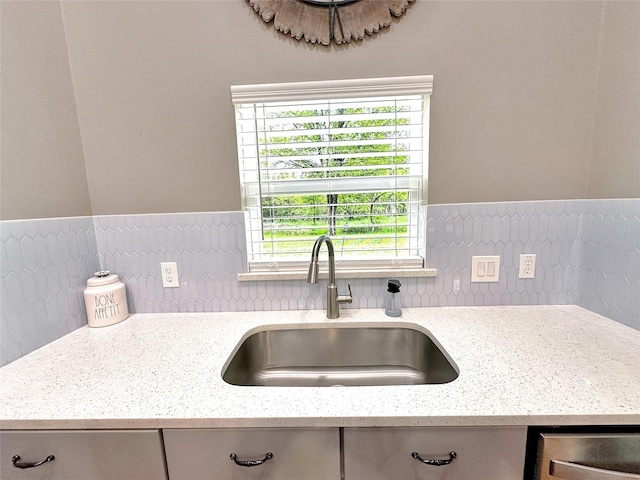 kitchen with sink, decorative backsplash, and light stone countertops