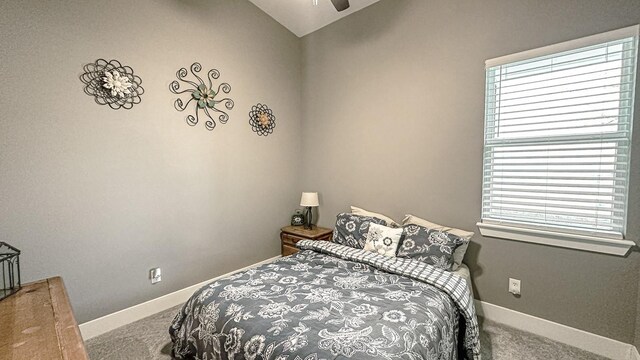 carpeted bedroom with ceiling fan and vaulted ceiling