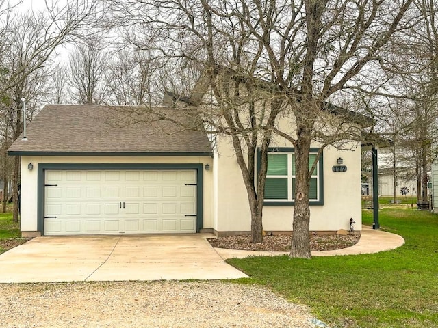 view of front of home with stucco siding, driveway, a front yard, and roof with shingles