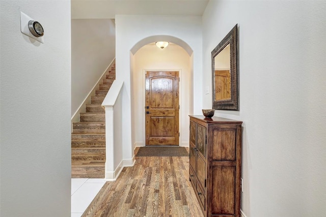 2210 Onion Creek Pkwy Unit 603, Austin, TX 78747 - entryway featuring arched walkways, wood finished floors, stairway, and baseboards