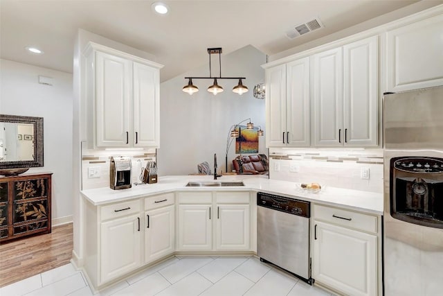 kitchen with decorative light fixtures, sink, white cabinets, decorative backsplash, and stainless steel appliances