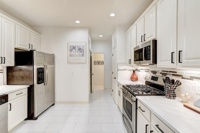 kitchen with light stone counters, appliances with stainless steel finishes, backsplash, and white cabinets