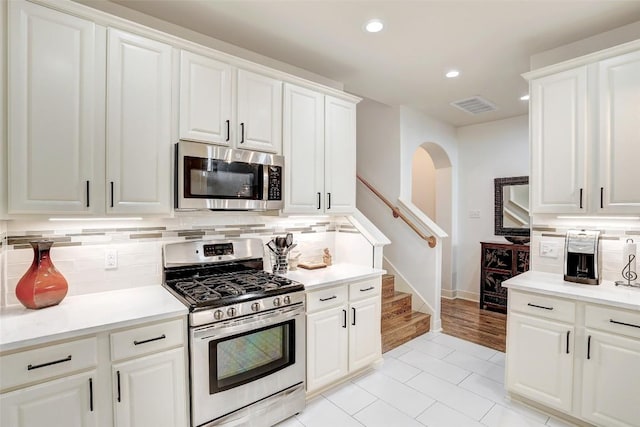 2210 Onion Creek Pkwy Unit 603, Austin, TX 78747 - kitchen featuring stainless steel appliances, decorative backsplash, recessed lighting, light countertops, and arched walkways