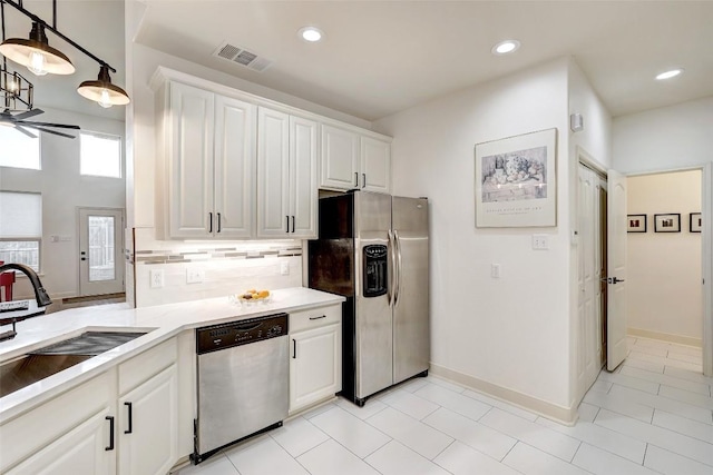 kitchen with visible vents, backsplash, white cabinetry, stainless steel appliances, and light countertops