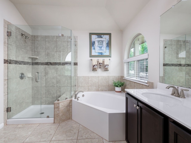 bathroom with vanity, shower with separate bathtub, tile patterned flooring, and vaulted ceiling