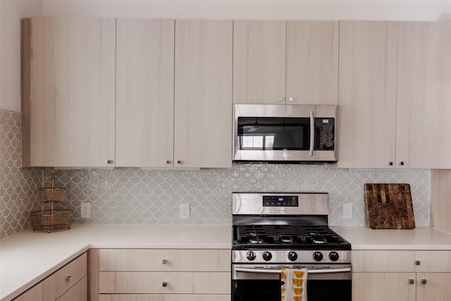 kitchen with light brown cabinetry, appliances with stainless steel finishes, and tasteful backsplash