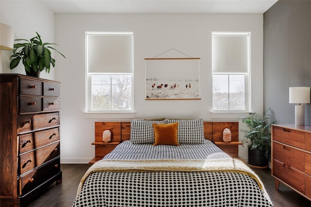 bedroom with dark wood-type flooring and multiple windows