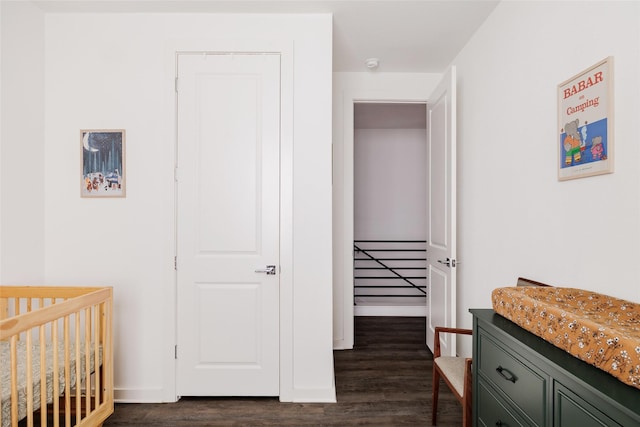 bedroom featuring dark hardwood / wood-style flooring and a crib