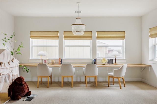 dining area featuring an inviting chandelier, a healthy amount of sunlight, and light colored carpet