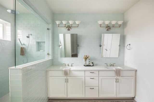 bathroom featuring backsplash, tiled shower, and vanity