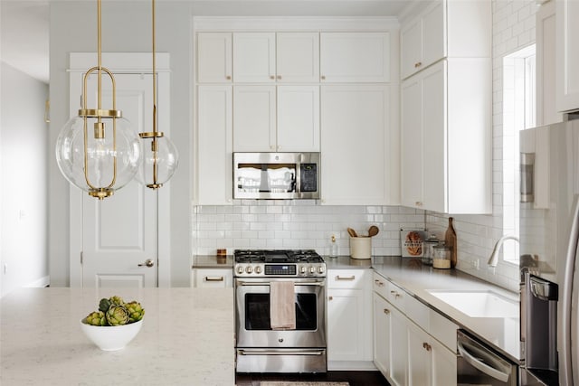 kitchen with hanging light fixtures, decorative backsplash, white cabinetry, appliances with stainless steel finishes, and sink