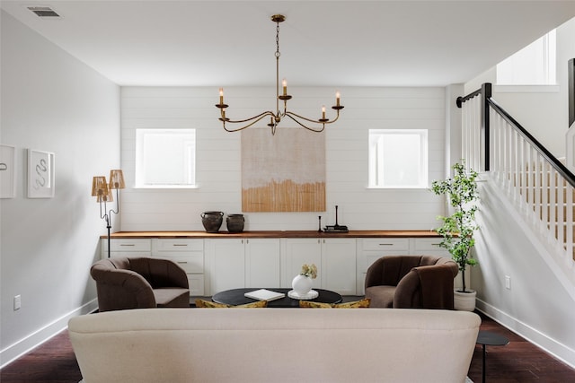 living room with dark hardwood / wood-style flooring, a chandelier, and a healthy amount of sunlight