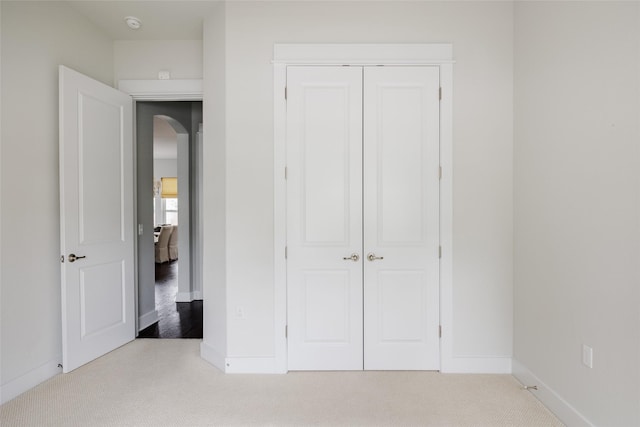 unfurnished bedroom with a closet and light carpet