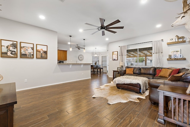 living room featuring ceiling fan and dark hardwood / wood-style floors