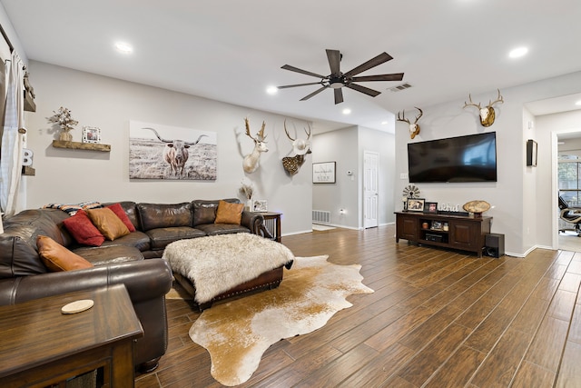 living room featuring ceiling fan and dark wood-type flooring