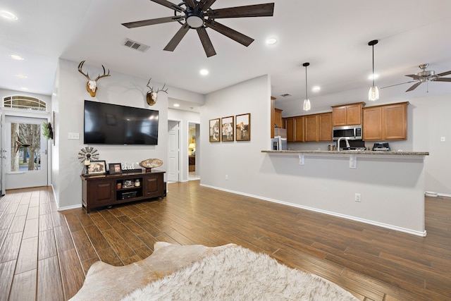 living room with ceiling fan and dark wood-type flooring