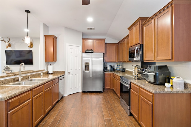 kitchen with vaulted ceiling, stainless steel appliances, dark hardwood / wood-style flooring, pendant lighting, and sink