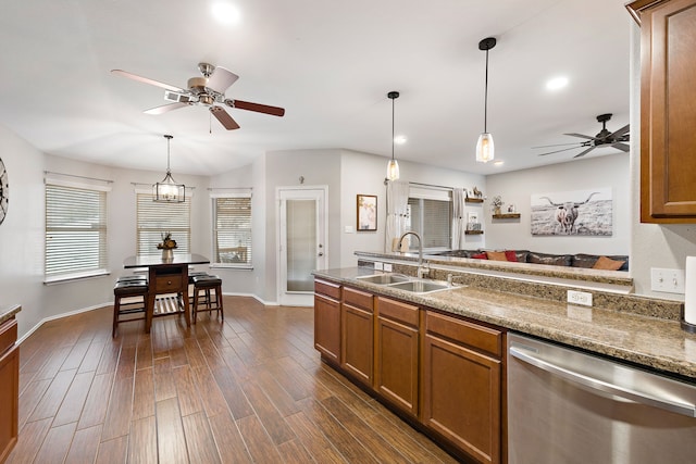 kitchen featuring decorative light fixtures, stainless steel dishwasher, dark hardwood / wood-style floors, and sink