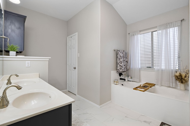 bathroom with lofted ceiling, a tub, and vanity