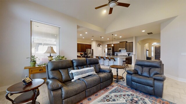 living room featuring high vaulted ceiling and ceiling fan