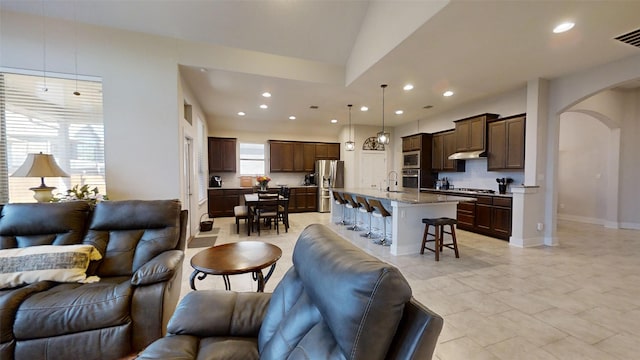 living room featuring lofted ceiling and sink