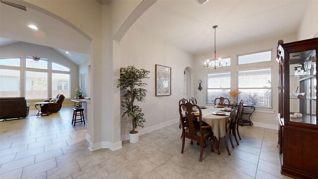 dining space with ceiling fan with notable chandelier and light tile patterned floors