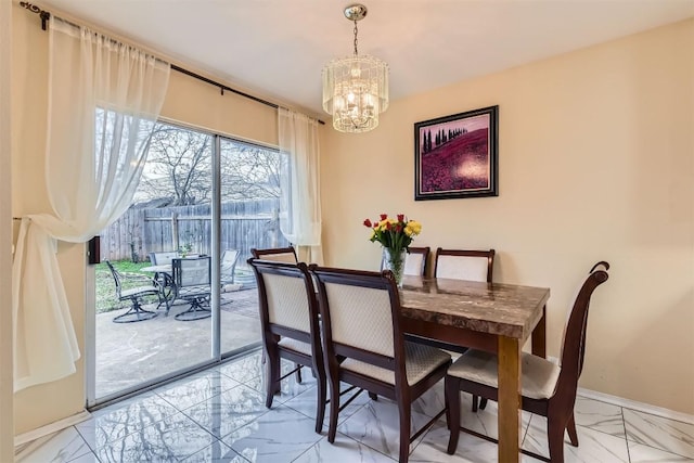 dining space featuring marble finish floor, baseboards, and a chandelier