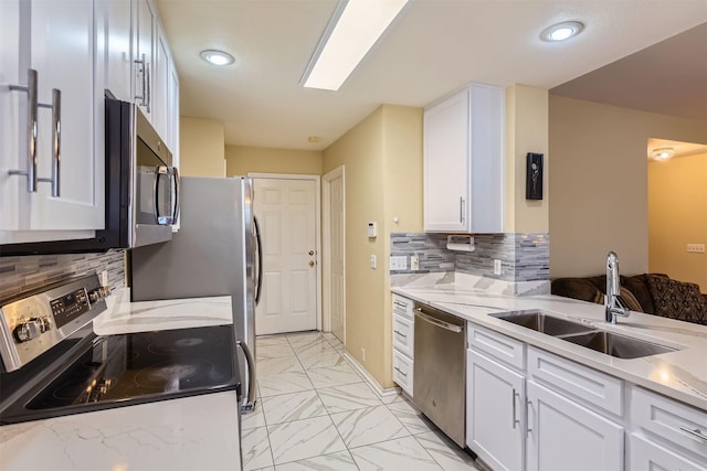 kitchen featuring light stone countertops, stainless steel appliances, decorative backsplash, white cabinetry, and sink