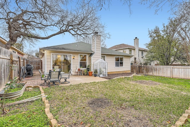 back of property featuring a fenced backyard, a patio, an outdoor structure, and a lawn