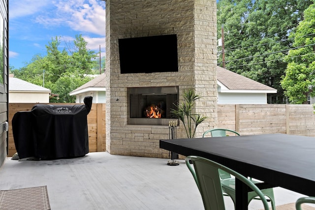 view of patio featuring a grill and an outdoor stone fireplace