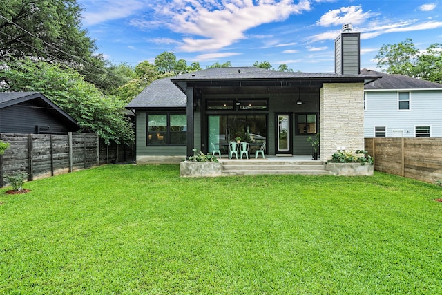 rear view of property with a patio area, ceiling fan, and a yard