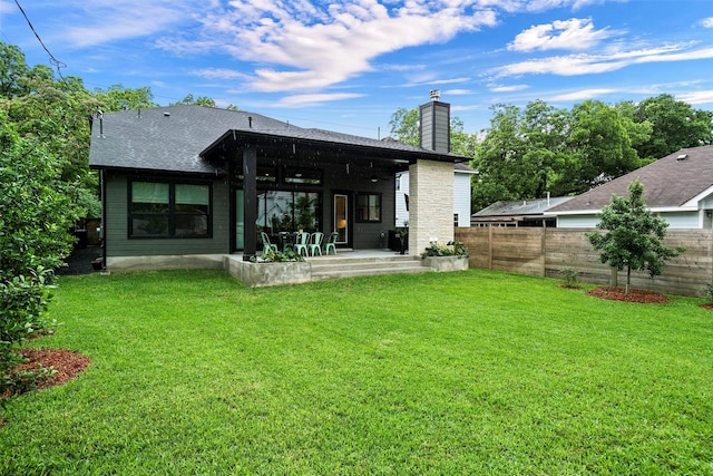 rear view of house featuring a yard and a patio area