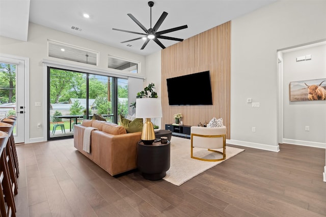 living room featuring wood-type flooring, ceiling fan, and a healthy amount of sunlight