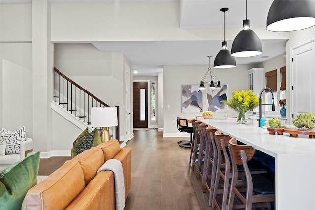 kitchen with decorative light fixtures, dark wood-type flooring, and a breakfast bar area