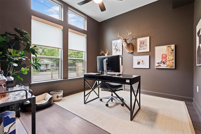 office area with wood-type flooring, ceiling fan, and a healthy amount of sunlight