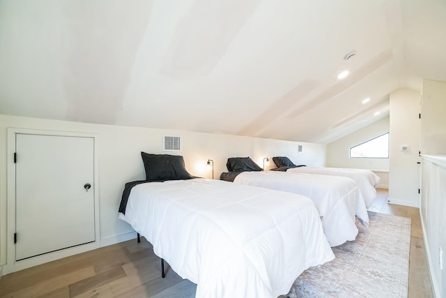 bedroom with vaulted ceiling and light hardwood / wood-style flooring