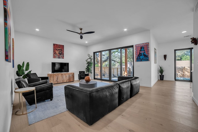 living room with ceiling fan, a wealth of natural light, and light wood-type flooring