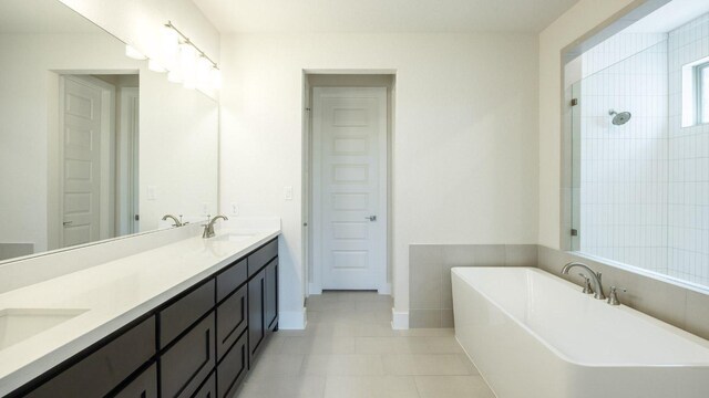 1728 Snowdrop Dr, Georgetown, TX 78628 - bathroom with a soaking tub, double vanity, and tile patterned flooring
