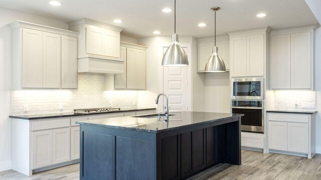 1728 Snowdrop Dr, Georgetown, TX 78628 - kitchen featuring stainless steel appliances, backsplash, light wood-style flooring, recessed lighting, and a kitchen island with sink