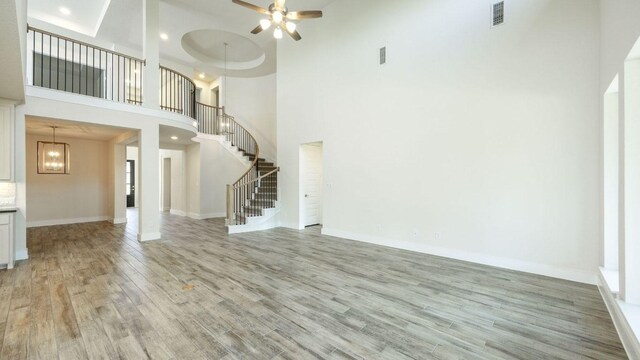 1728 Snowdrop Dr, Georgetown, TX 78628 - unfurnished living room featuring a high ceiling, stairway, light wood-style floors, ceiling fan, and recessed lighting