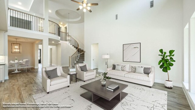 1728 Snowdrop Dr, Georgetown, TX 78628 - living room featuring a high ceiling, light wood-style floors, stairway, and ceiling fan