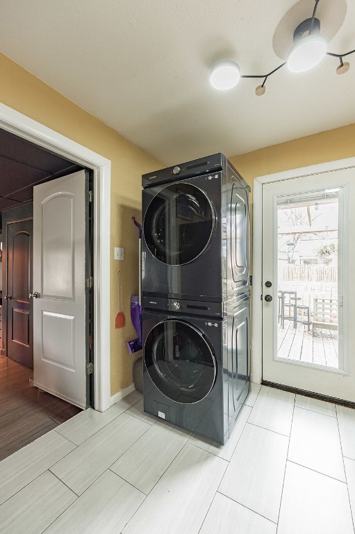 405 W 17th St, Georgetown, TX 78626 - laundry room featuring baseboards, stacked washer and dryer, laundry area, and wood finished floors