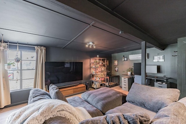 living room with beam ceiling, wood finished floors, and a wall mounted air conditioner