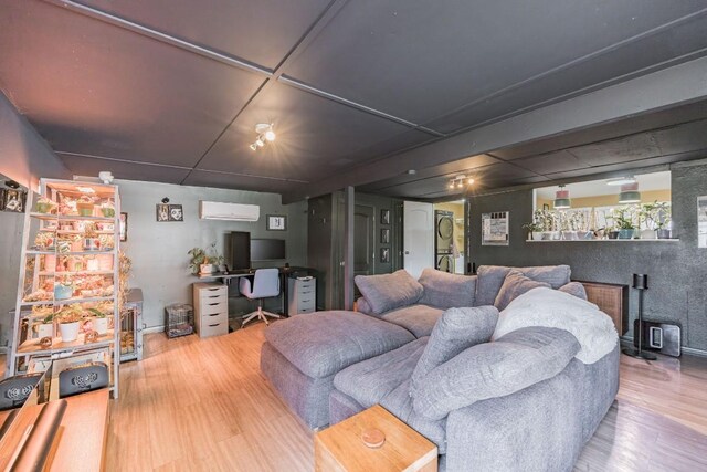 living room featuring hardwood / wood-style flooring and a wall unit AC