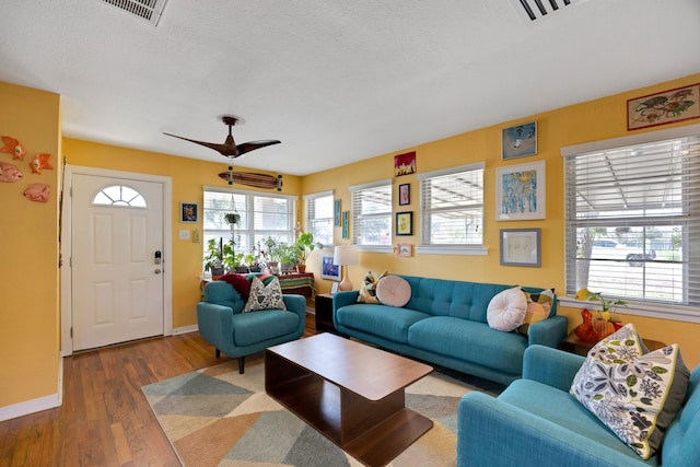 living room with hardwood / wood-style floors, a textured ceiling, plenty of natural light, and ceiling fan