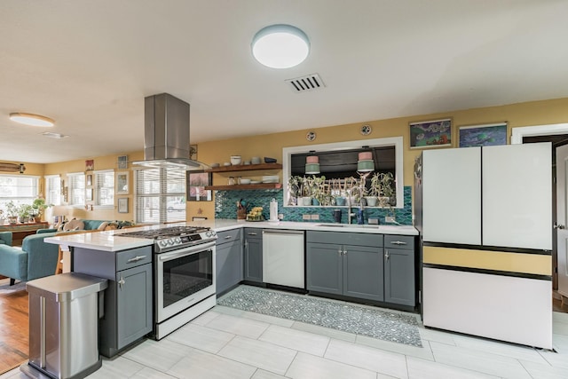 kitchen featuring gray cabinets, sink, island exhaust hood, kitchen peninsula, and stainless steel appliances