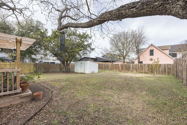 view of yard featuring a storage shed, an outdoor structure, and a fenced backyard