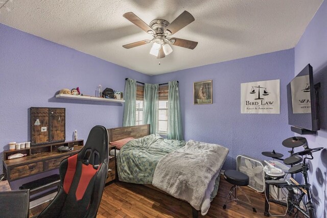 bedroom featuring dark wood-type flooring, a textured ceiling, and ceiling fan